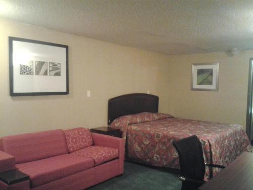 a hotel room with a couch and a bed at Xenia Country Inn in Xenia
