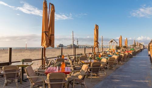 a row of tables and chairs on the beach at 2 rooms Sea Breeze loft apartment II terrace family Scheveningen The Hague in Scheveningen