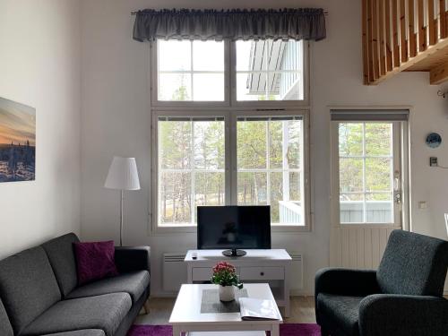 a living room with two couches and a tv at Vuorsa 1 A 2 in Saariselka