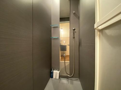 uma casa de banho com um chuveiro, um lavatório e um espelho. em Kyunoju em Okayama