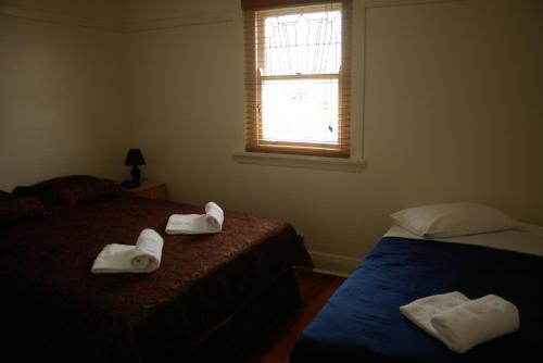 2 Betten in einem Zimmer mit Handtüchern auf dem Bett in der Unterkunft Accommodation Sydney Rockdale in Sydney