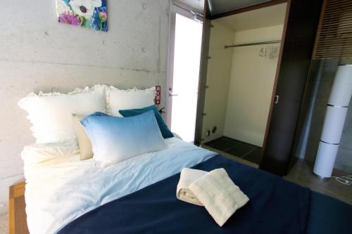 a bedroom with a blue and white bed and a mirror at Kaze -SEVEN Hotels and Resorts- in Higashi