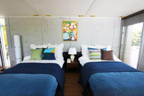 two beds in a room with blue and white at Kaze -SEVEN Hotels and Resorts- in Higashi