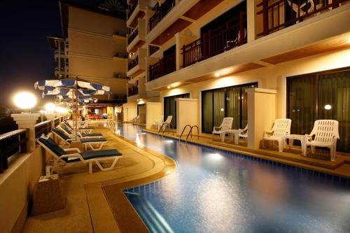 Jiraporn Hill Resort في شاطيء باتونغ: مسبح الفندق مع كراسي الصالة والمظلات