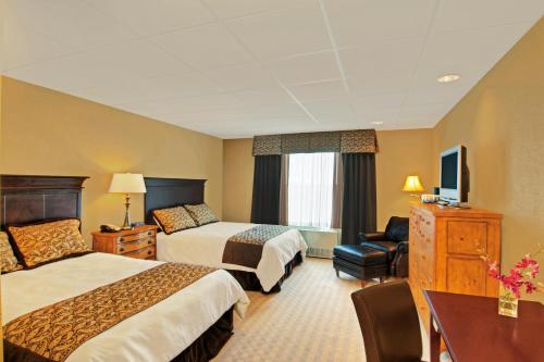 a hotel room with two beds and a desk at The Pointe at Castle Hill Resort & Spa in Ludlow