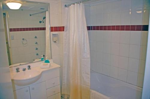 a bathroom with a shower curtain and a sink at Accommodation Sydney - Pitt Street in Sydney