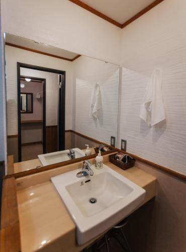 a bathroom with a white sink and a mirror at Niseko Ski Lodge - Hirafu in Kutchan