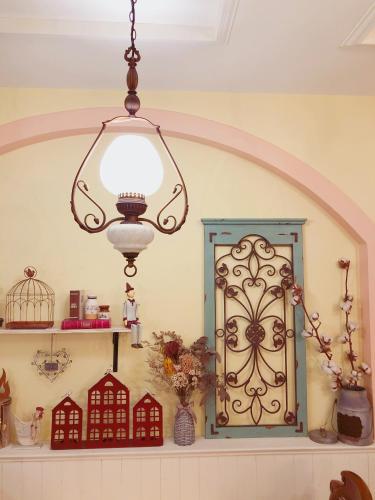 a chandelier hanging over a shelf with a window at Fazhana Village B&B in Hualien City