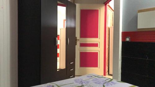a bedroom with a bed and a door with red accents at Domaine De Titine in Bonneville
