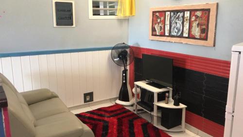 a living room with a chair and a flat screen tv at Domaine De Titine in Bonneville