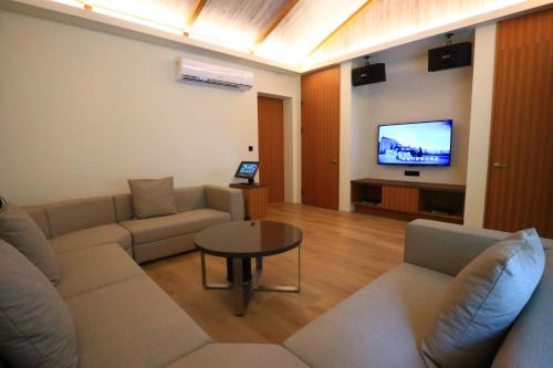 a living room with a couch and a tv at Shu Xin Motel in Nantou City