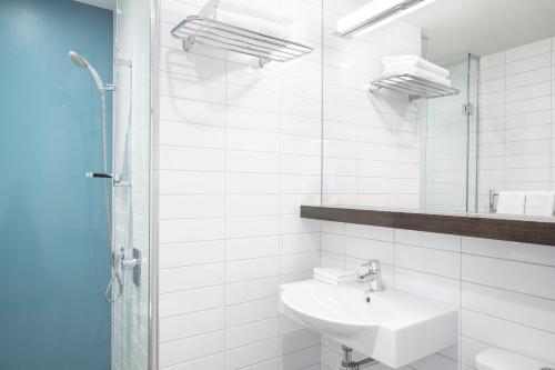 a white bathroom with a sink and a shower at Peppers Bluewater Resort in Lake Tekapo