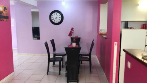 a dining room with a table and a clock on the wall at Domaine De Titine in Bonneville