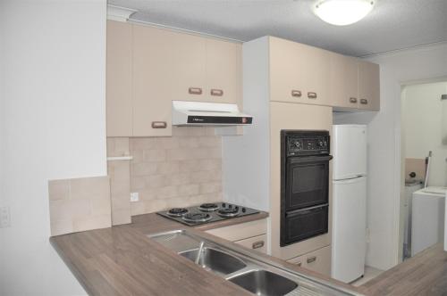 a kitchen with a sink and a stove top oven at Accommodation Sydney - Kent Street Sydney CBD Top floor 2 bedroom apartment with balcony in Sydney