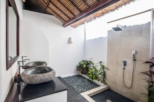 een badkamer met een stenen wastafel en een douche bij Villa Michiko in Uluwatu