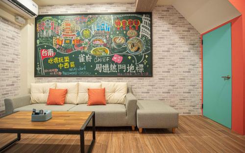 a living room with a couch and a painting on the wall at Chief Homestay輕旅套房附設電梯#本國旅客須先匯款 in Tainan