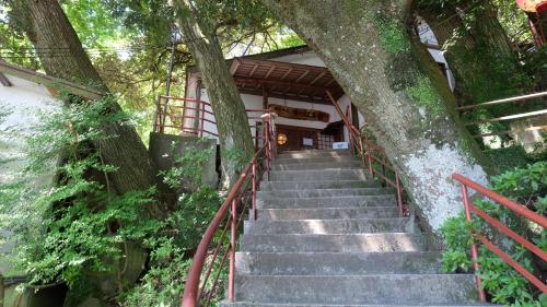 a set of stairs leading up to a building with a tree at Kappa Tengoku in Hakone