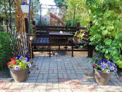 a bench in a garden with two potted plants at Hotel Veagles in Narva-Jõesuu