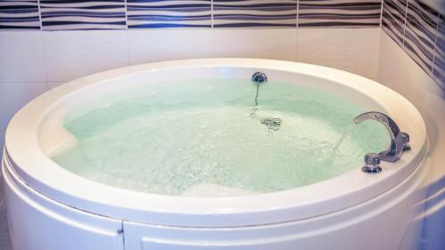 a bath tub with a faucet with water in it at Venezia Hotel in Suncheon