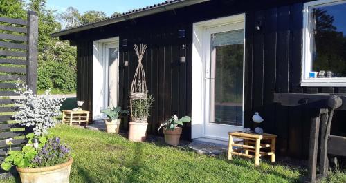 a black house with potted plants next to a door at Karens Bakke 2 in Glesborg