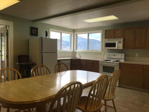 a kitchen with a table and chairs and a refrigerator at D'Angelo Winery Farm House in Penticton