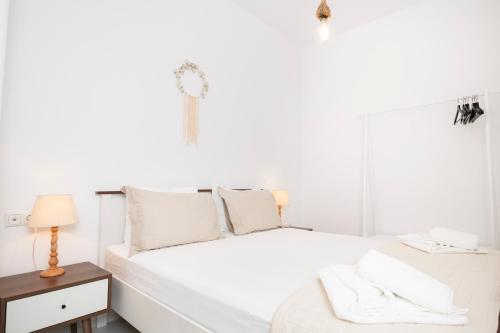a white bedroom with a white bed and a window at Arsis Houses, Small House in Antiparos
