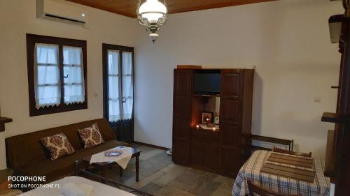 sala de estar con sofá y TV en Villa Belian 1, en Argalasti