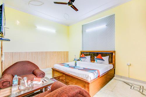 a bedroom with a bed and a chair at FabExpress Royal Ashray in Noida