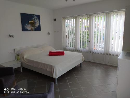 a bedroom with a bed with a red towel on it at Tomić in Novi Vinodolski