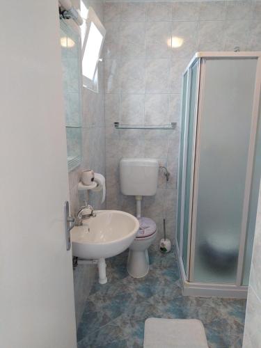 a bathroom with a toilet and a sink and a shower at Tomić in Novi Vinodolski