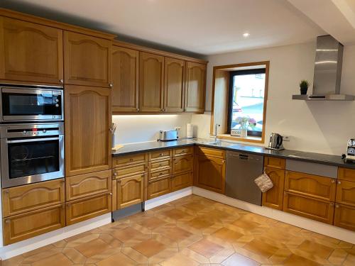 a large kitchen with wooden cabinets and a window at Ferienwohnung Hopfengarten in Spalt