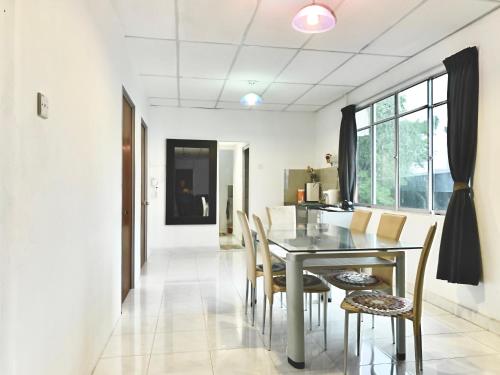 a dining room with a table and chairs at Singtown Guesthouse in Mersing