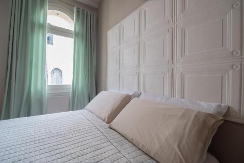 a bedroom with a bed with white sheets and a window at Appartamento Delle Vele in Venice