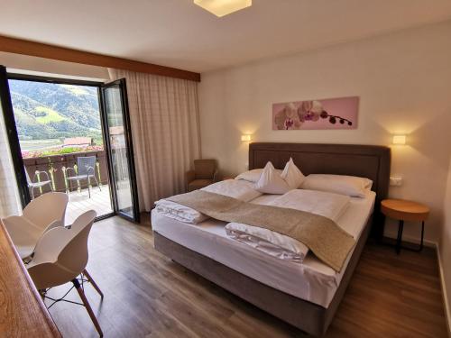 a bedroom with a large bed and a balcony at Garni Weghueb in Rablà