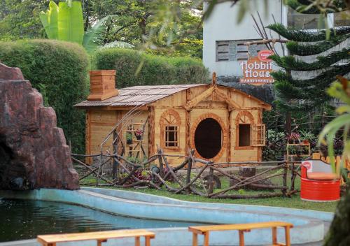 a small wooden dog house in a garden at HARRIS Hotel Sentul City Bogor in Bogor