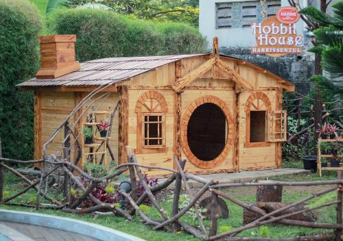 a small wooden dog house in a garden at HARRIS Hotel Sentul City Bogor in Bogor