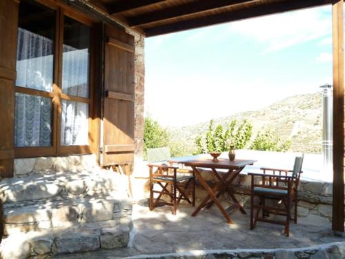 patio con mesa, sillas y ventana en ANOI 1-bedroom country House, en Episkopi Pafou