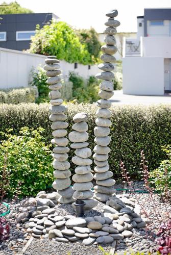 a spiralling stack of rocks in a garden at Bellano Motel Suites in Christchurch