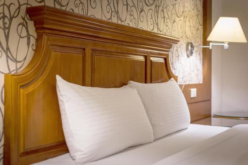 a bed with a wooden headboard and a white pillow at Guide Hotel Zhongli Zhongzheng in Zhongli