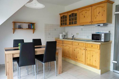 een keuken met houten kasten en een houten tafel en stoelen bij Ferienwohnung Krebs in Hooksiel