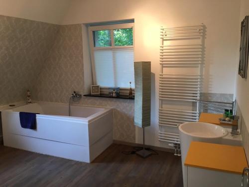 a bathroom with a white tub and a sink at Ferienwohnung Villa am Schloßberg in Bad Berka