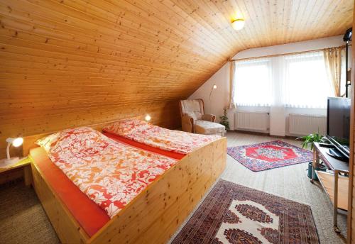 ein Schlafzimmer mit einem Bett in einem Holzzimmer in der Unterkunft Ferienwohnung Balbach,"Haus Hella" in Lauda-Königshofen