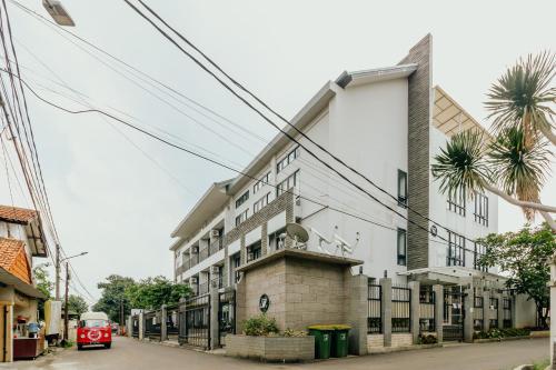 a building on a street with a red bus at Urbanest Inn House TB Simatupang in Jakarta