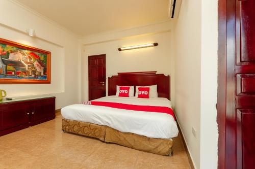 una camera da letto con un grande letto con cuscini rossi di Sunlight Hotel Hạ Long a Ha Long