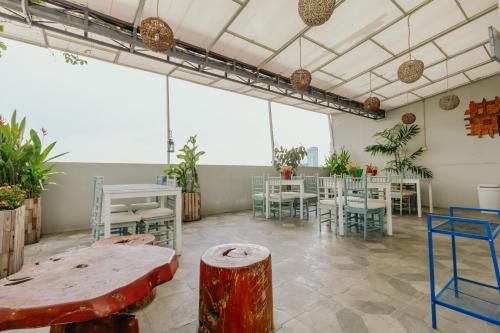 a large room with tables and chairs and plants at Urbanest Inn House TB Simatupang in Jakarta