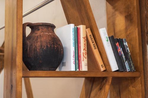 a book shelf with a vase and books on it at Guest house Diabora-Veliko Tarnovo in Veliko Tŭrnovo