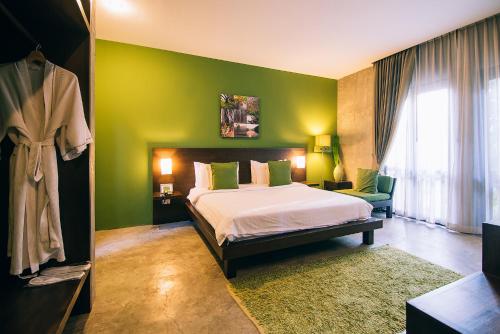 a bedroom with a bed and a green wall at Ketawa Pet Friendly Hotel in Chiang Mai