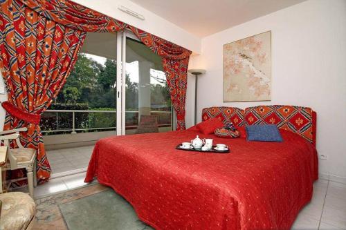 a bedroom with a red bed and a window at Riviera Golf de Barbossi Indiana in Mandelieu-la-Napoule