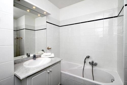 une salle de bain blanche avec une baignoire et un lavabo dans l'établissement Riviera Golf de Barbossi Indiana, à Mandelieu-la-Napoule