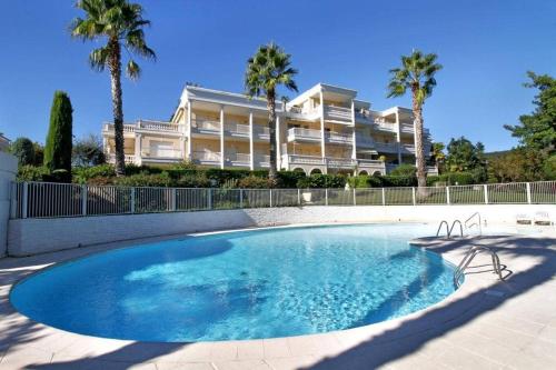 une grande piscine en face d'un grand bâtiment dans l'établissement Riviera Golf de Barbossi Indiana, à Mandelieu-la-Napoule